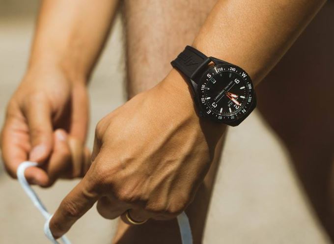 Alpina AlpinerX Hybrid Smartwatch am Handgelenk beim Schuhe schnüren