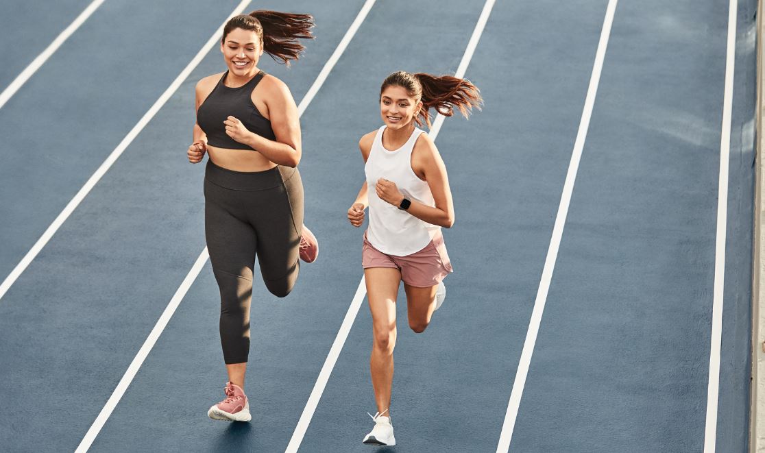 Zwei Frauen joggen mit Versa 2 Smartwatch am Handgelenk Zwei Frauen joggen mit Versa 2 Smartwatch am Handgelenk