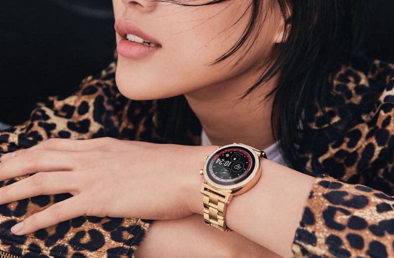 michael kors access sofie 2 smartwatch am handgelenk einer dame mit verschraenkten armen