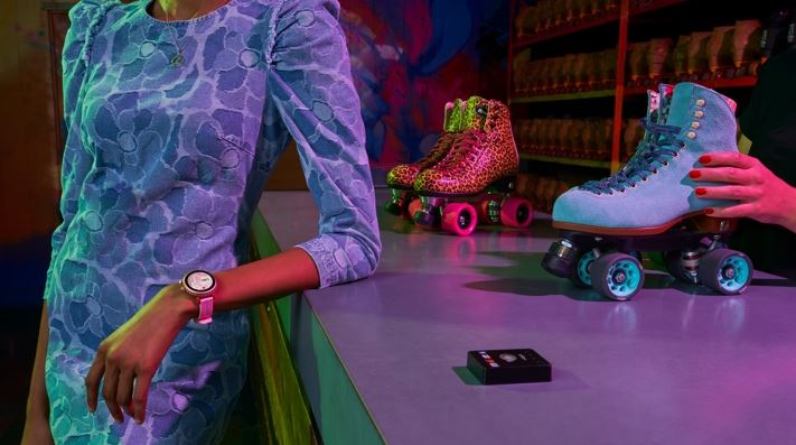 Frau lehnt mit Kate Spade New York Sport Smartwatch am Tresen Frau lehnt mit Kate Spade New York Sport Smartwatch am Tresen