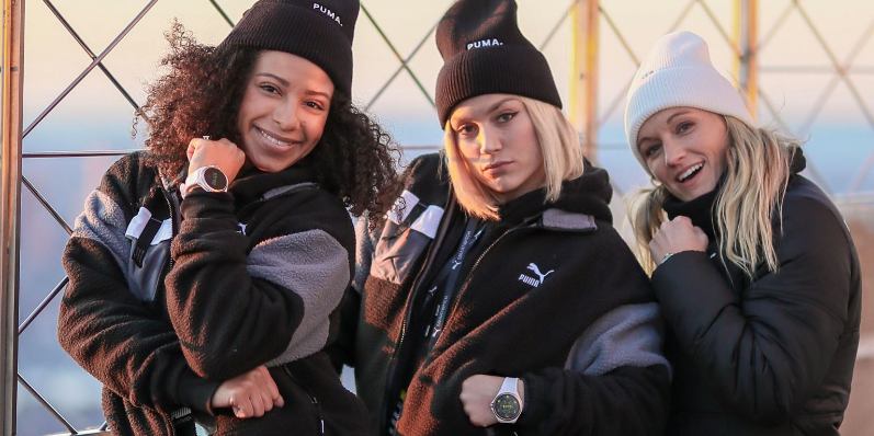 Drei Damen posieren mit Puma Smartwatch am Handgelenk Drei Damen posieren mit Puma Smartwatch am Handgelenk