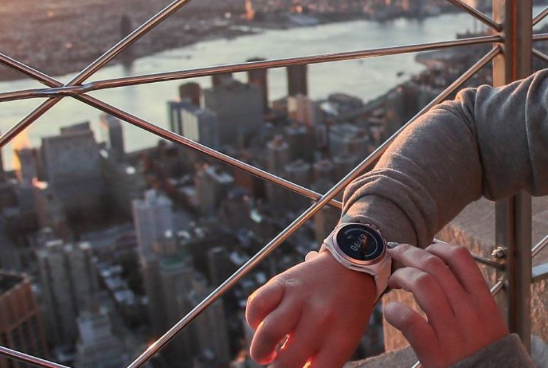 Frau tippt auf Puma Smartwatch über Dächern einer Großstadt Frau tippt auf Puma Smartwatch über Dächern einer Großstadt