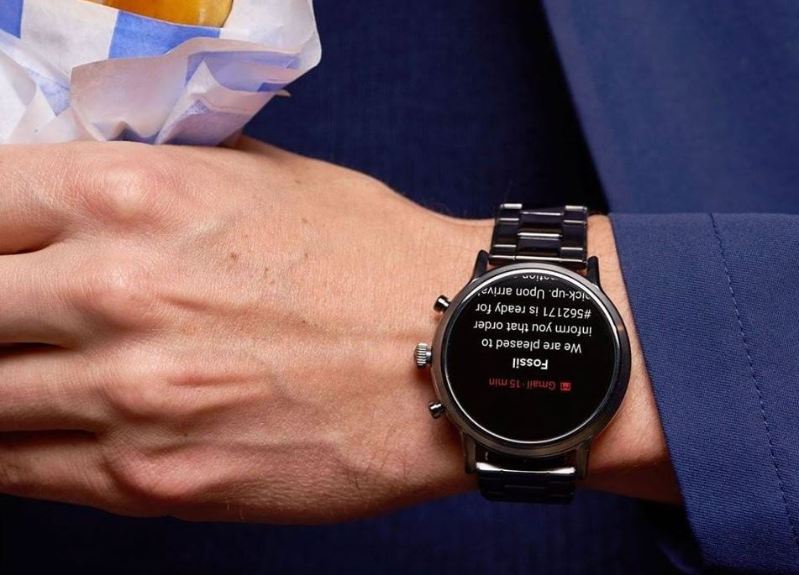 Herr mit Anzug trägt Fossil Carlyle HR Smartwatch am Handgelenk Herr mit Anzug trägt Fossil Carlyle HR Smartwatch am Handgelenk
