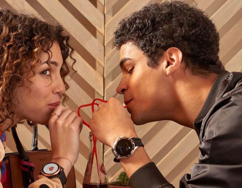 Frau und Mann mit Fossil Garrett HR Smartwatch am Handgelenk trinken aus einem Glas mit Strohhalmen