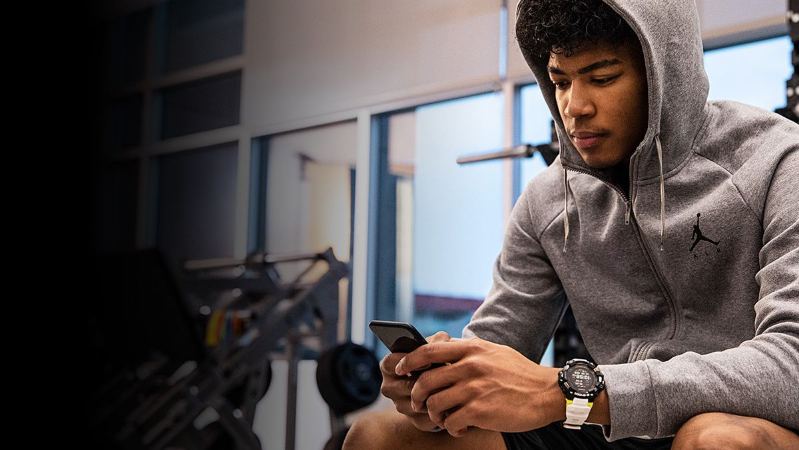 mann trägt casio gbd-h1000 am handgelenk und wertet sein training auf dem smartphone aus mann trägt casio gbd-h1000 am handgelenk und wertet sein training auf dem smartphone aus